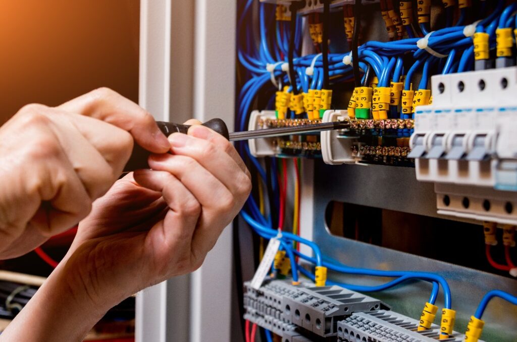 The man is repairing the switchboard voltage with automatic switches.